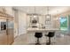Modern kitchen with white cabinets, a large island, and stainless steel appliances, perfect for cooking and entertaining at 491 Daylily Blvd, Nokomis, FL 34275
