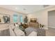 Bright living room features a cozy sofa, geometric rug, and a media center with a large screen TV at 491 Daylily Blvd, Nokomis, FL 34275