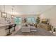 Open-concept living room with modern decor, pendant lighting, and large windows bringing natural light at 491 Daylily Blvd, Nokomis, FL 34275