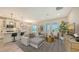 Open-concept living room with modern decor, pendant lighting, and large windows bringing natural light at 491 Daylily Blvd, Nokomis, FL 34275