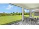 Screened-in patio with a dining table set, showcasing a view of the large green backyard at 491 Daylily Blvd, Nokomis, FL 34275