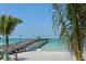 Picturesque view of the pier stretching into the ocean, framed by palm trees on a sunny day at 491 Daylily Blvd, Nokomis, FL 34275