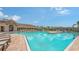 Community pool with clear blue water, lounge chairs, and a view of the clubhouse at 491 Daylily Blvd, Nokomis, FL 34275