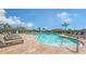 Community pool featuring plenty of lounge chairs, clear skies, and lush landscaping at 491 Daylily Blvd, Nokomis, FL 34275