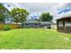 A large backyard with green grass, a gazebo and a gray house with white trim and a wood fence at 5415 13Th Avenue W Dr, Bradenton, FL 34209