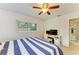 Bright bedroom features a ceiling fan, white walls and window, and a bathroom with a vanity at 5415 13Th Avenue W Dr, Bradenton, FL 34209