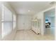 Entryway with neutral tile flooring, white walls, a glass display cabinet and a view into another room at 5415 13Th Avenue W Dr, Bradenton, FL 34209