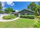 Delightful gray single-story home with inviting front yard, trimmed bushes, and brick pathway at 5415 13Th Avenue W Dr, Bradenton, FL 34209