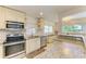 Bright kitchen with stainless steel appliances and granite counters, next to eating area at 5415 13Th Avenue W Dr, Bradenton, FL 34209