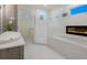 Modern bathroom featuring a walk-in shower, free-standing tub with a fireplace, and a stylish vanity at 5630 Inspiration Ter, Bradenton, FL 34210