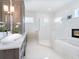Elegant bathroom featuring a modern vanity, walk-in shower, tub and unique fireplace at 5630 Inspiration Ter, Bradenton, FL 34210