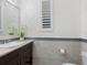 A modern bathroom features designer wallpaper and elegant fixtures and finishings at 5630 Inspiration Ter, Bradenton, FL 34210
