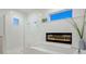 Luxurious bathroom featuring a walk-in shower, a tub with a fireplace, and modern fixtures at 5630 Inspiration Ter, Bradenton, FL 34210