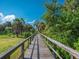 Picturesque wooden boardwalk surrounded by lush greenery and palm trees at 5630 Inspiration Ter, Bradenton, FL 34210