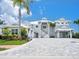 Stunning coastal home featuring a light gray exterior, white trim, and a spacious paved driveway at 5630 Inspiration Ter, Bradenton, FL 34210