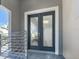 Close-up of stylish double front doors with modern hardware and elegant trim at 5630 Inspiration Ter, Bradenton, FL 34210