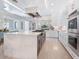 Bright kitchen featuring stainless steel appliances, a large island, and an open layout leading to the living area at 5630 Inspiration Ter, Bradenton, FL 34210
