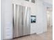 A modern kitchen featuring stainless steel refrigerator and built-in appliances with white cabinets at 5630 Inspiration Ter, Bradenton, FL 34210
