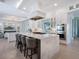 Spacious kitchen featuring a large island with seating, stainless steel appliances, and modern white cabinetry at 5630 Inspiration Ter, Bradenton, FL 34210