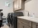 Well-organized laundry room with modern washer and dryer, ample cabinetry, and a practical utility sink at 5630 Inspiration Ter, Bradenton, FL 34210