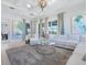 Bright living room featuring a coffered ceiling, large windows, and a comfortable white sectional sofa at 5630 Inspiration Ter, Bradenton, FL 34210