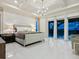 A bright main bedroom features a chandelier, tray ceiling, and large windows at 5630 Inspiration Ter, Bradenton, FL 34210