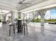 Entertaining area with a large table, bar stools, and stairs to the pool at 5630 Inspiration Ter, Bradenton, FL 34210