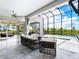 Spacious covered patio with stylish seating, overlooking the pool, lake and outdoor entertainment area at 5630 Inspiration Ter, Bradenton, FL 34210