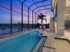 Stunning screened-in pool with waterfront views and lounge chairs at sunset at 5630 Inspiration Ter, Bradenton, FL 34210