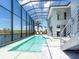 Luxurious pool with tranquil lake views, enclosed within a screened-in lanai, and comfortable lounge seating at 5630 Inspiration Ter, Bradenton, FL 34210