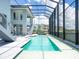 Stunning outdoor pool featuring a screened-in enclosure, a jacuzzi, and a serene view of the lake at 5630 Inspiration Ter, Bradenton, FL 34210