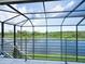 Screened porch offering serene lake view with landscaping and custom railing at 5630 Inspiration Ter, Bradenton, FL 34210