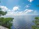 Beautiful waterfront property view with calm waters under a blue, partly cloudy sky offering a serene atmosphere at 5630 Inspiration Ter, Bradenton, FL 34210