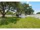 Wide backyard shot featuring a storage shed, mature tree, and green grass at 5685 36Th N Ave, St Petersburg, FL 33710