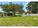 Wide backyard shot featuring a storage shed, mature trees, and lush green grass at 5685 36Th N Ave, St Petersburg, FL 33710