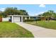Charming single-story home features a well-manicured lawn, a sunny yellow front door, and a long driveway at 5685 36Th N Ave, St Petersburg, FL 33710