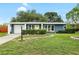 Charming single-story home features a well-manicured lawn, a sunny yellow front door, and an attached one-car garage at 5685 36Th N Ave, St Petersburg, FL 33710