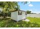 Backyard shed with a white door, window, and mature landscaping at 5685 36Th N Ave, St Petersburg, FL 33710