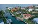 Gorgeous aerial view of waterfront homes with docks, boats, lush landscaping, and sparkling canals leading to the open bay at 571 Birdie Ln, Longboat Key, FL 34228