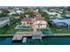 Aerial view of a waterfront home with a pool, spa, dock, and lush landscaping at 571 Birdie Ln, Longboat Key, FL 34228