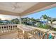 Waterfront balcony featuring an ornate stone table and four chairs overlooking palm trees and the scenic waterway at 571 Birdie Ln, Longboat Key, FL 34228