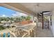 This waterfront balcony features an ornate stone table and chairs with spiral stairs and views of palm trees at 571 Birdie Ln, Longboat Key, FL 34228