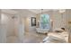 A luxurious bathroom with a clawfoot tub, chandelier, a tiled shower with double sink marble countertops at 571 Birdie Ln, Longboat Key, FL 34228