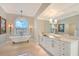 Bathroom features a clawfoot tub, chandelier, arched window, double sinks, and marble countertops at 571 Birdie Ln, Longboat Key, FL 34228
