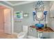 Bathroom with a unique blue glass vessel sink and creative decorations at 571 Birdie Ln, Longboat Key, FL 34228