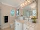 Bathroom featuring a marble vanity with decorative mirror and lighting at 571 Birdie Ln, Longboat Key, FL 34228