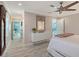 Bright bedroom featuring a modern white dresser, decorative mirror, and entry into the bathroom at 571 Birdie Ln, Longboat Key, FL 34228