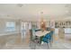 Bright and airy dining area featuring marble floors, a contemporary chandelier, and open access to the kitchen and living spaces at 571 Birdie Ln, Longboat Key, FL 34228