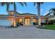Elegant home featuring a paver driveway, lush landscaping, and white columns that highlight the front entrance at 571 Birdie Ln, Longboat Key, FL 34228