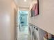 Hallway view of laundry area and bathroom with unique blue glass vessel sink at 571 Birdie Ln, Longboat Key, FL 34228